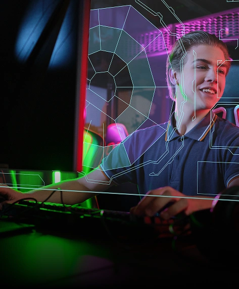 Een glimlachende persoon zit te gamen op een computer, verlicht door levendige groene en paarse lichten. Een futuristische digitale interface bedekt het beeld en creëert een boeiende sfeer